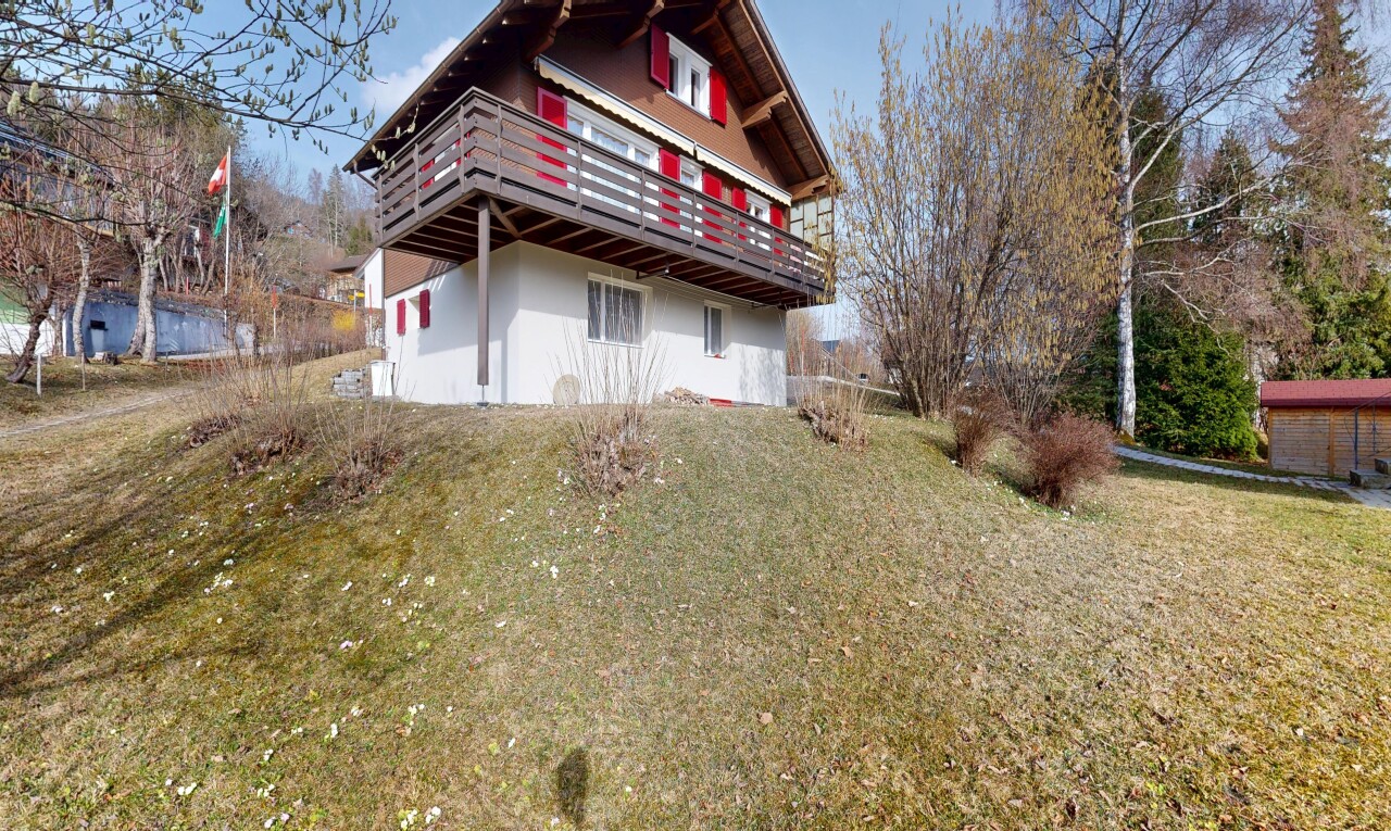 outdoor house featuring a balcony, stucco siding, and a yard