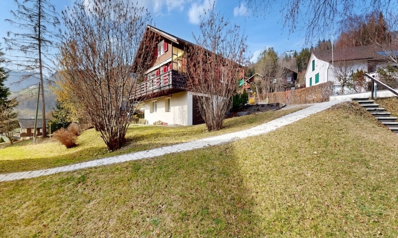 outdoor house with a lawn and a balcony