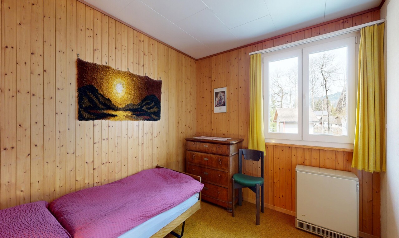 room / bedroom with heating unit, wood walls, and light colored carpet