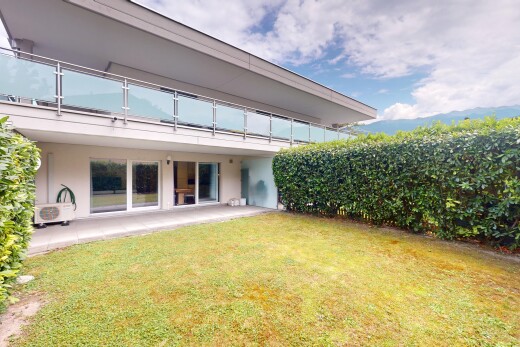 außenansicht mit balkon, rasen, property visible, stuckverkleidung, und day time