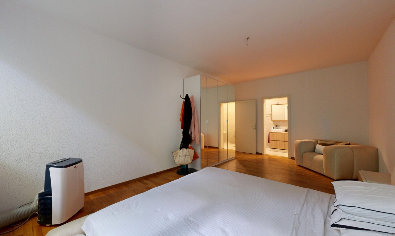room / bedroom with wood finished floors and ensuite bathroom
