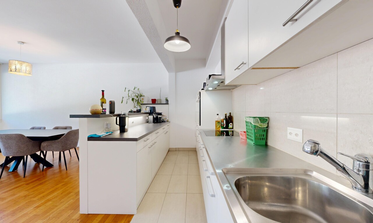 kitchen with white cabinets, a peninsula, decorative backsplash, and hanging light fixtures