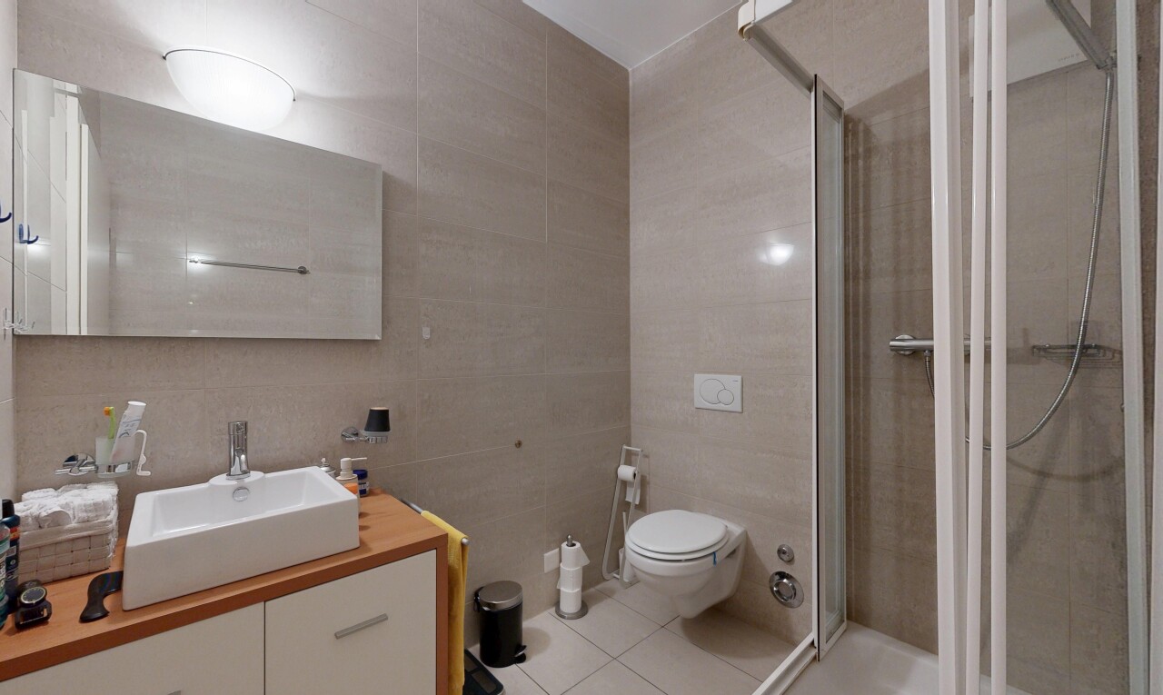 full bathroom with tile walls, a stall shower, vanity, and light tile patterned floors