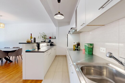 kitchen with white cabinets, a peninsula, decorative backsplash, and hanging light fixtures