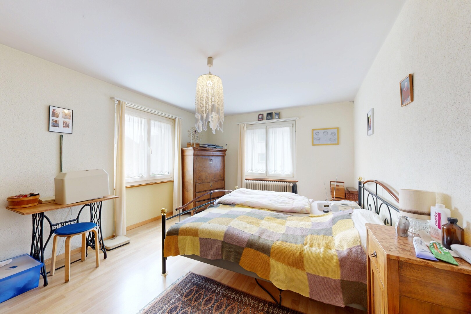 room with light wood-type flooring, multiple windows, radiator heating unit, and a chandelier