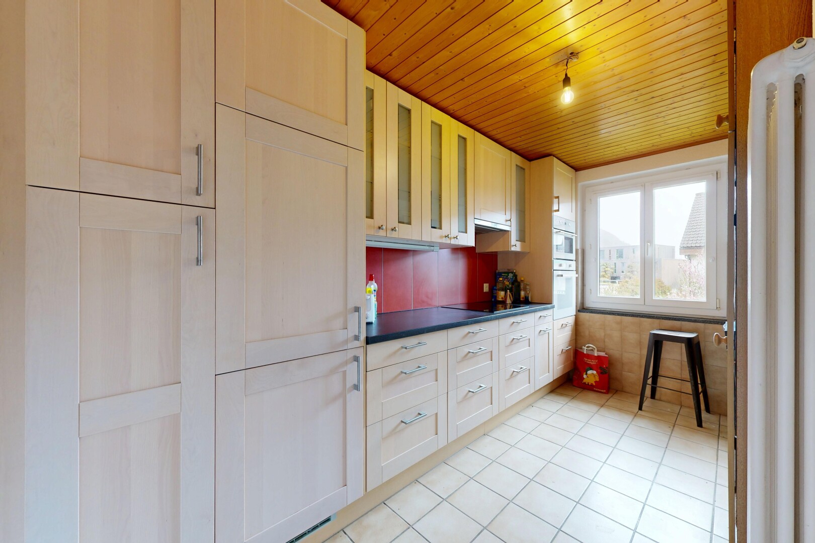 kitchen featuring dark countertops, wood ceiling, glass insert cabinets, light tile patterned floors, and black electric stovetop