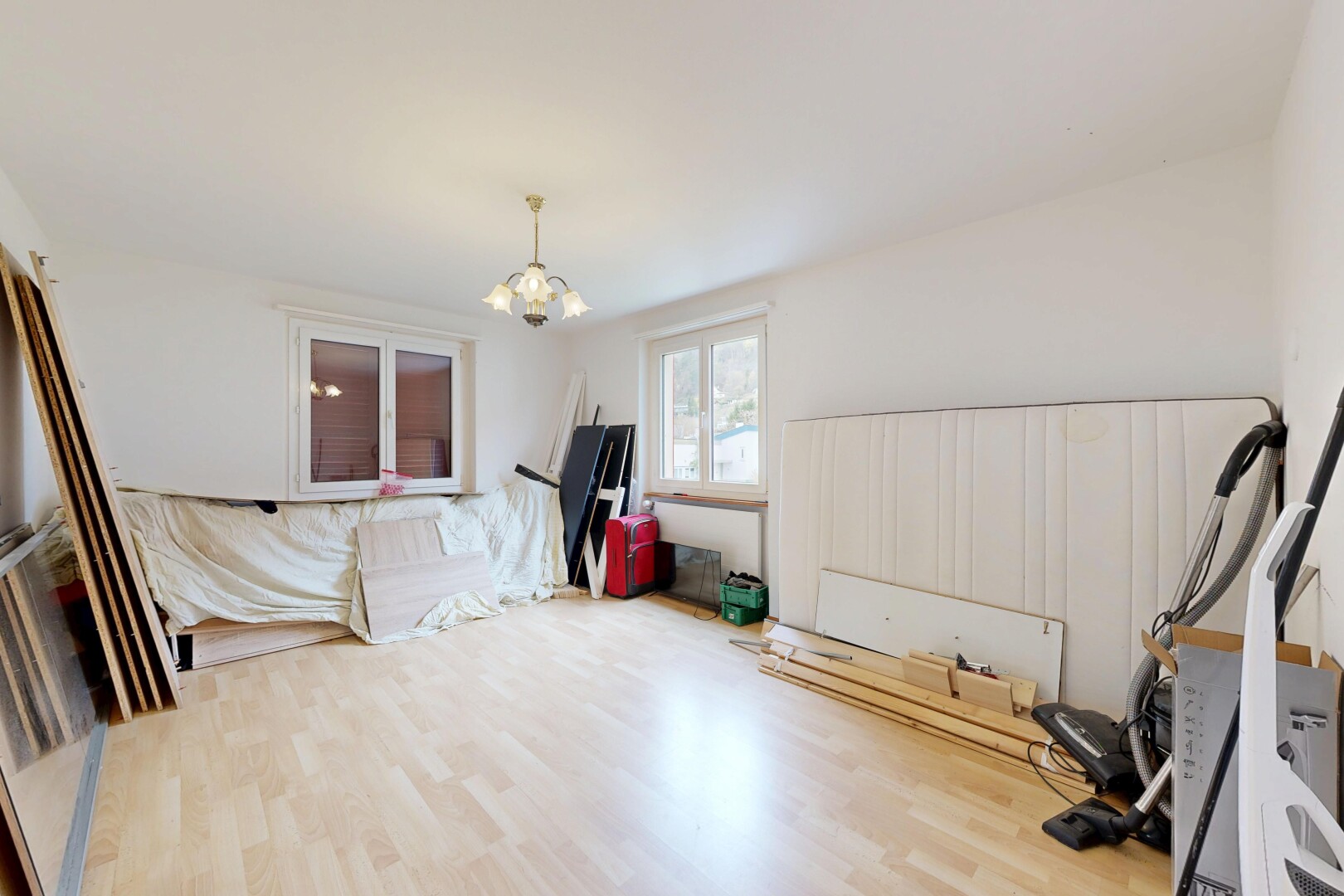 unfurnished living room featuring wood finished floors and suspended lighting