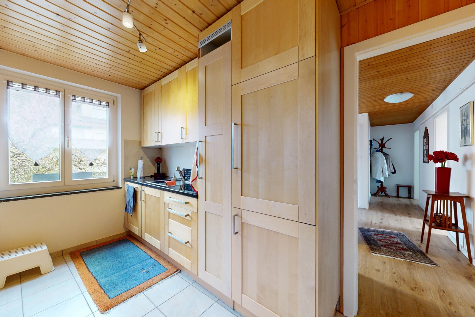 kitchen with wood ceiling, dark countertops, and light wood finish cabinetry