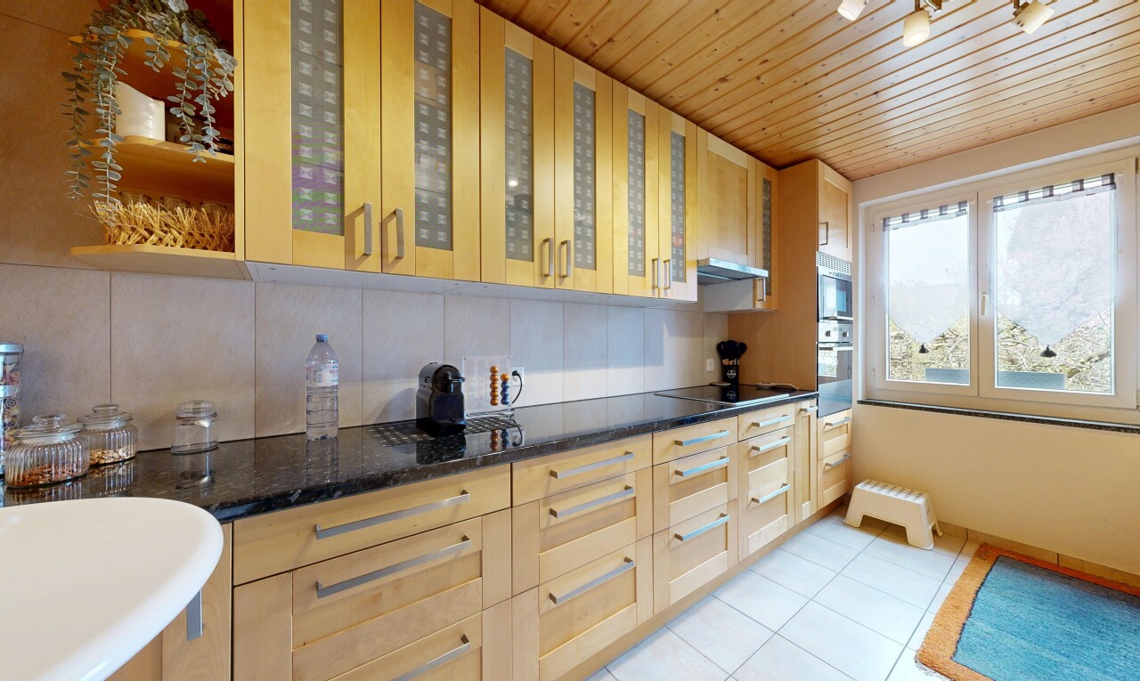 kitchen featuring light wood finish cabinets, glass fronted cabinets, dark stone counters, light tile patterned flooring, and wood ceiling