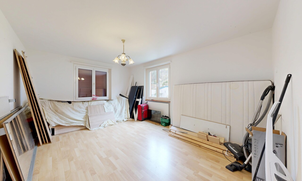 unfurnished living room featuring wood finished floors and suspended lighting