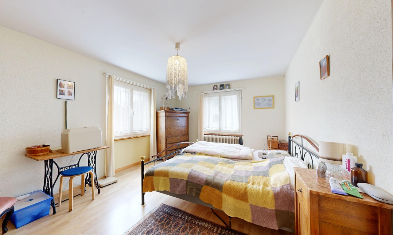 room with light wood-type flooring, multiple windows, radiator heating unit, and a chandelier