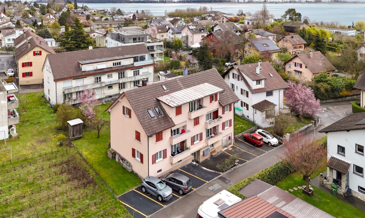 outdoor house with uncovered parking, a water view, and a residential view