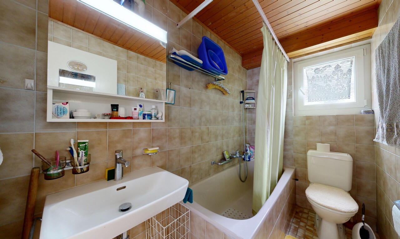 full bath with tile walls, tiled shower / bath combo, and wood ceiling