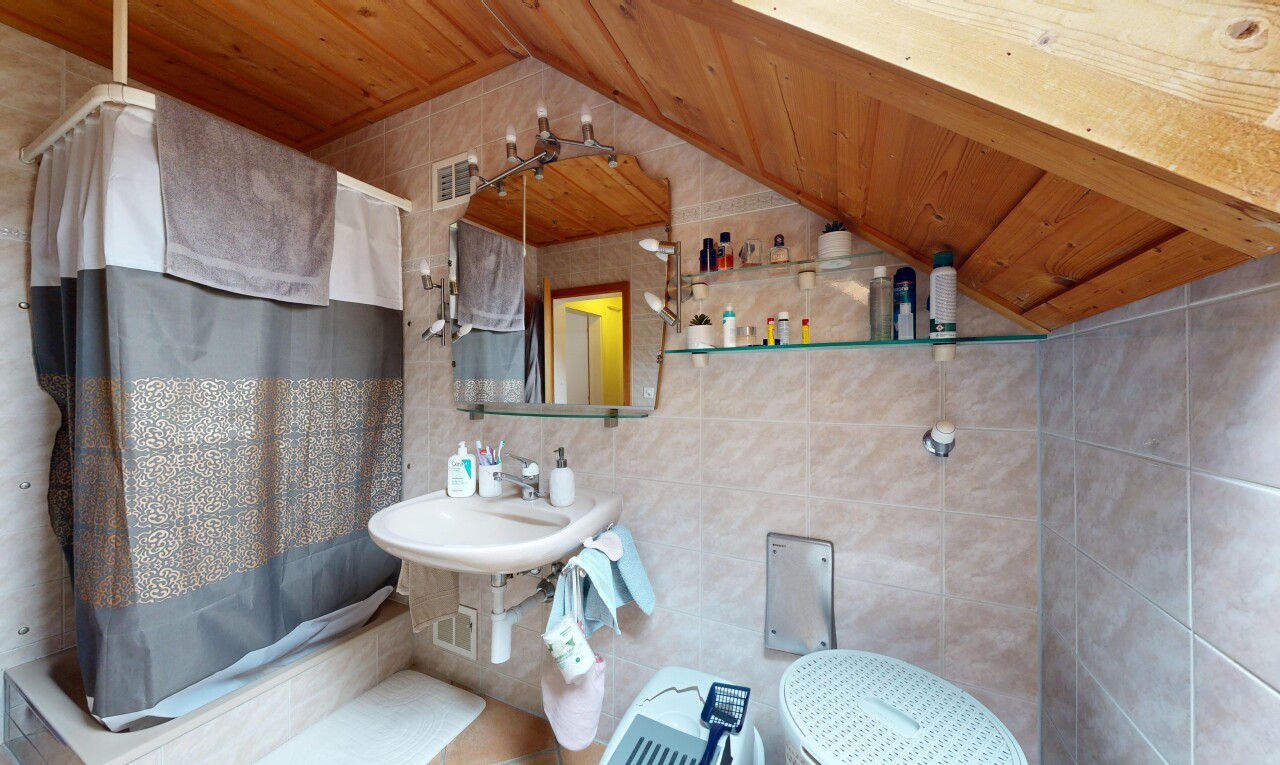 bathroom with tile walls, a vaulted wooden ceiling, tiled shower / bath combo, and decorative backsplash