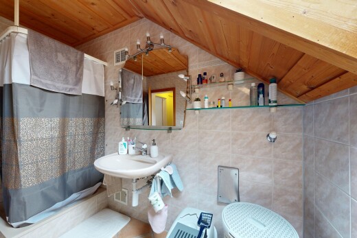 bathroom with tile walls, a vaulted wooden ceiling, tiled shower / bath combo, and decorative backsplash
