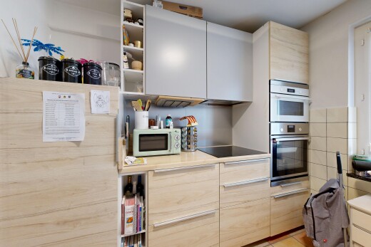kitchen with white microwave, open shelves, stainless steel double oven, light countertops, and black electric stovetop