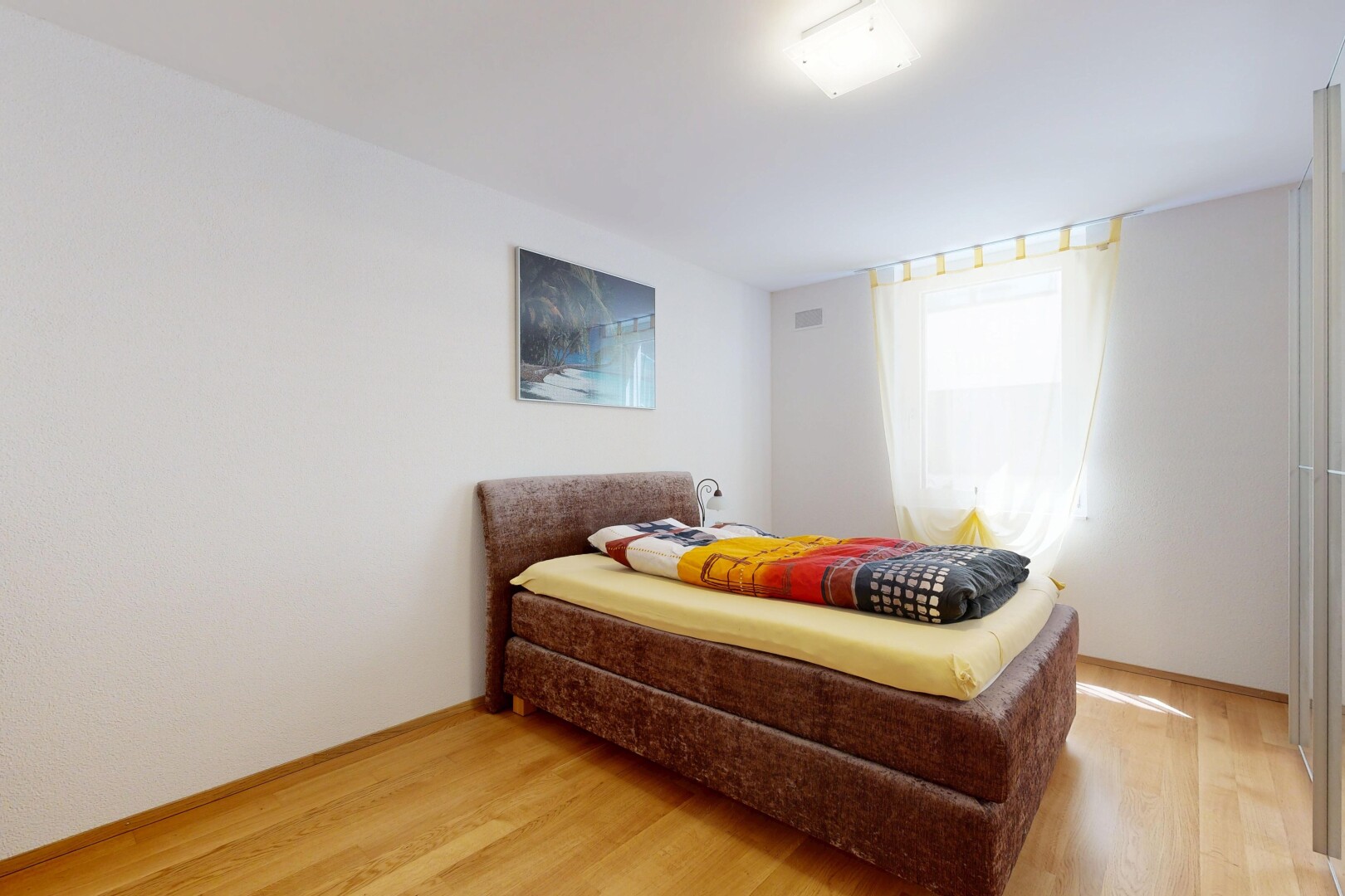 zimmer / schlafzimmer mit natürliches licht, wood finish floor, holzfußboden, drywall, und gipskartonwand