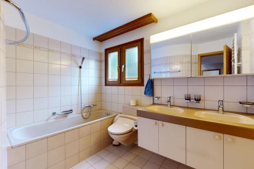 bathroom with tasteful backsplash, light tile patterned floors, tiled shower / bath, double vanity, and tile walls