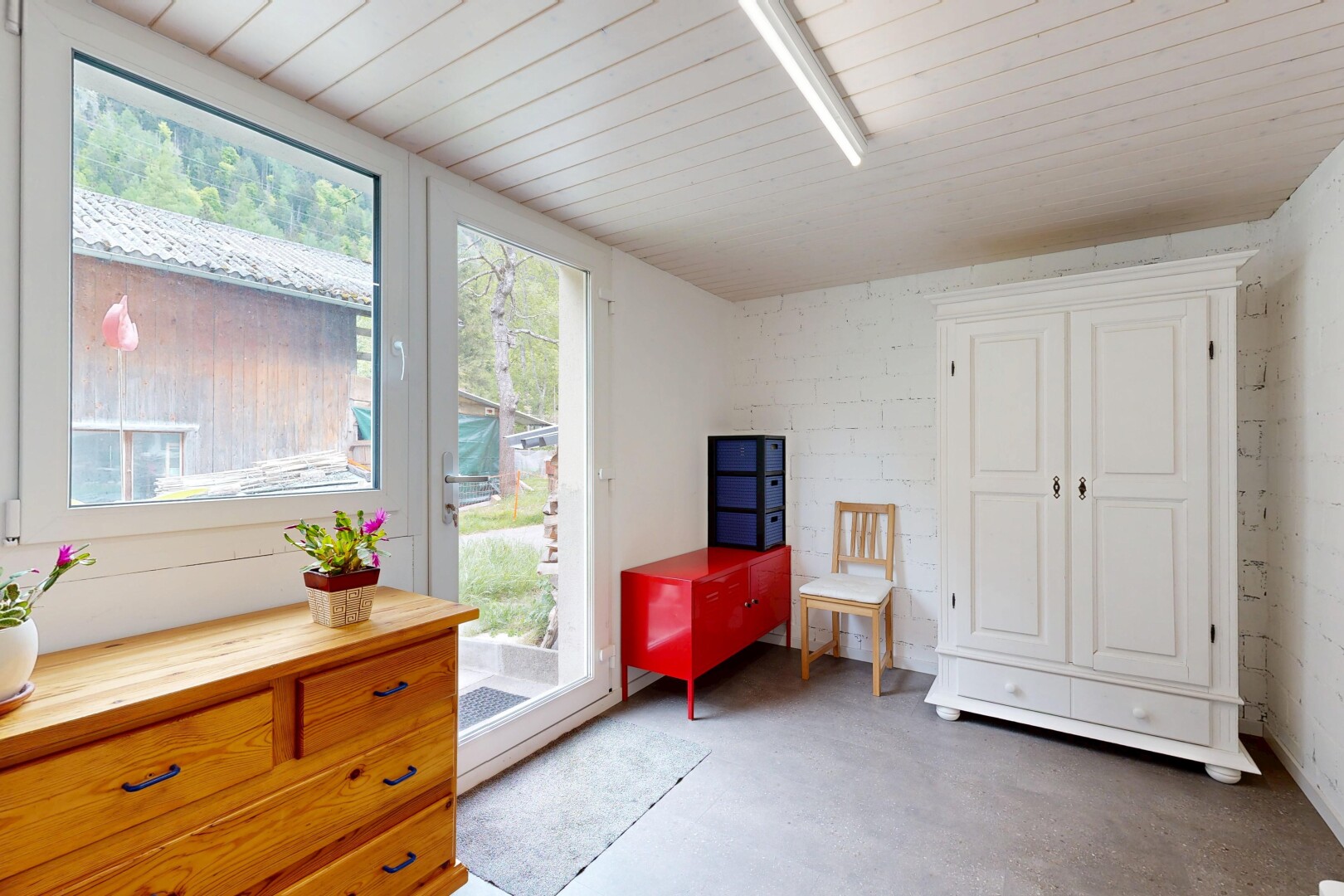 zimmer / schlafzimmer mit betonboden, concrete floor, inside property, außenzugang, und light floor