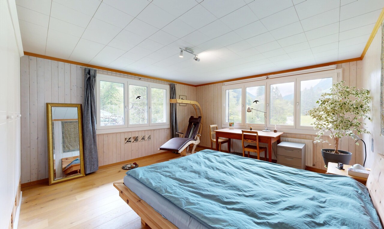 zimmer / schlafzimmer mit holzfußboden, wood finish floor, inside property, holzwand, und wood wall