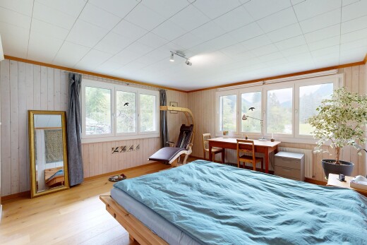 zimmer / schlafzimmer mit holzfußboden, wood finish floor, inside property, holzwand, und wood wall