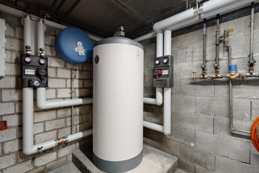 détails avec plumbing, chauffe-eau, wall / siding, et appliance