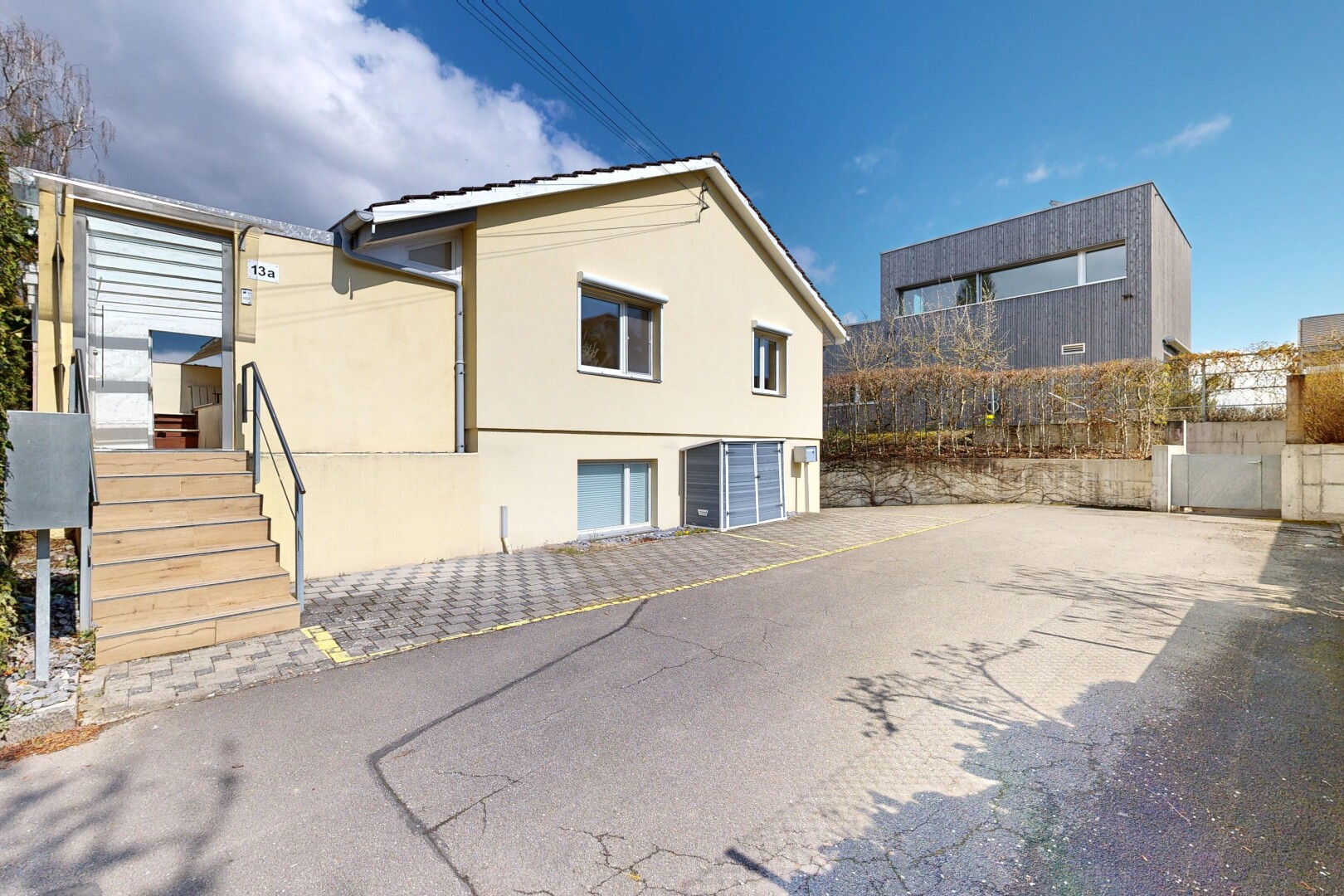 außenansicht mit eingebaute garage, day time, property visible, stuckverkleidung, und auffahrt