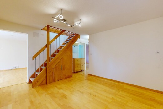 pièce vide avec cloison sèche, drywall, escaliers, sol en finition bois, et wood finish floor