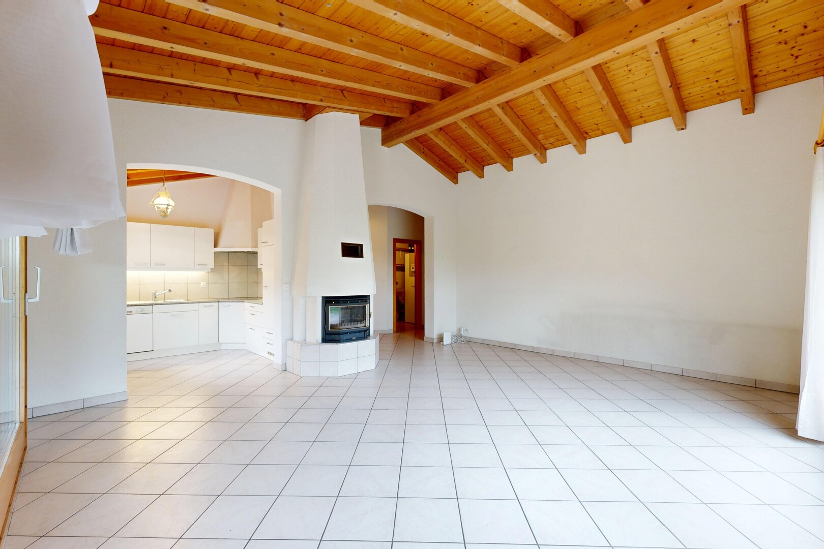 pièce vide avec vaulted ceiling, plafond voûté, inside property, light floor, et beamed ceiling
