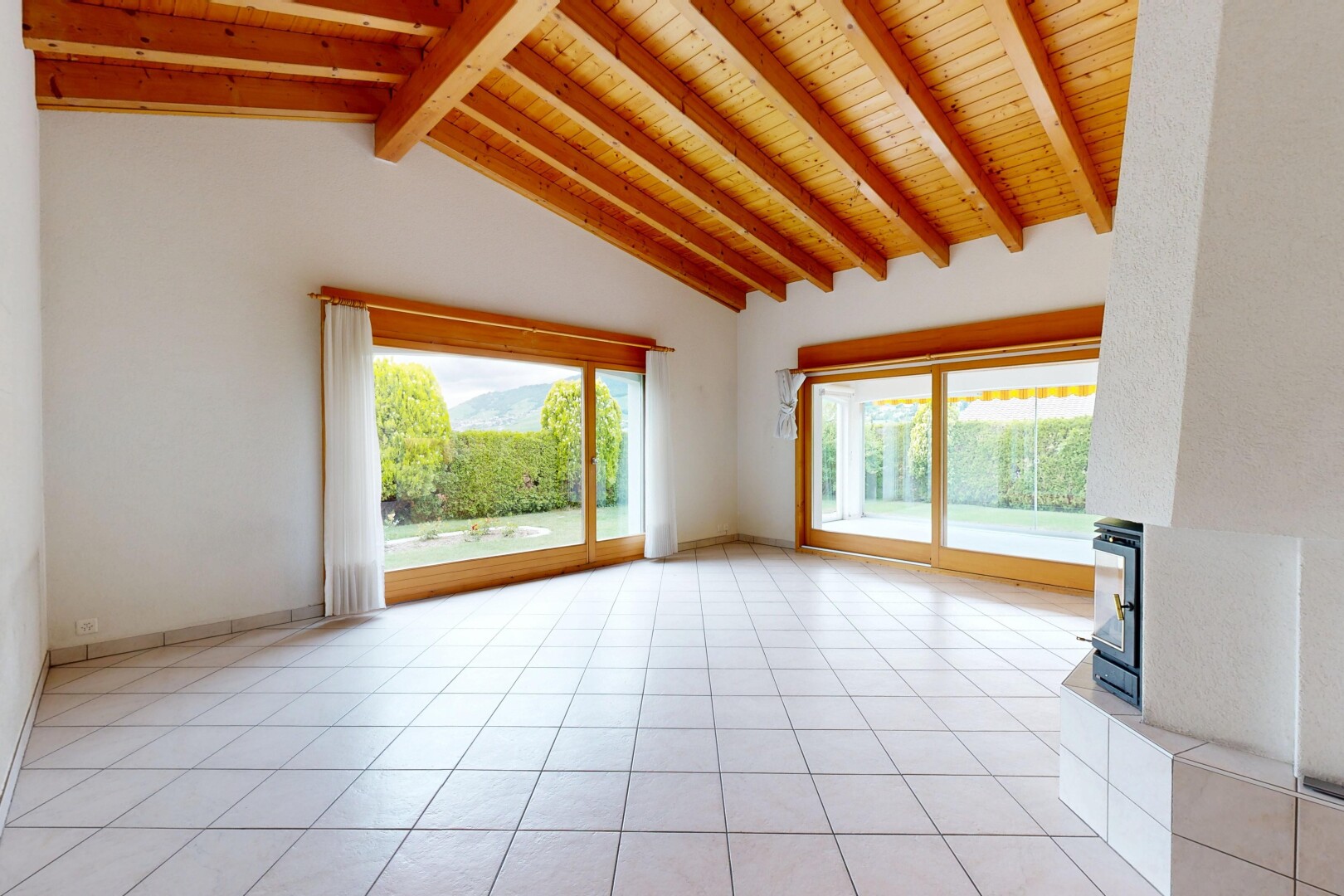 pièce vide avec inside property, light floor, beamed ceiling, plafond à poutres, et natural light