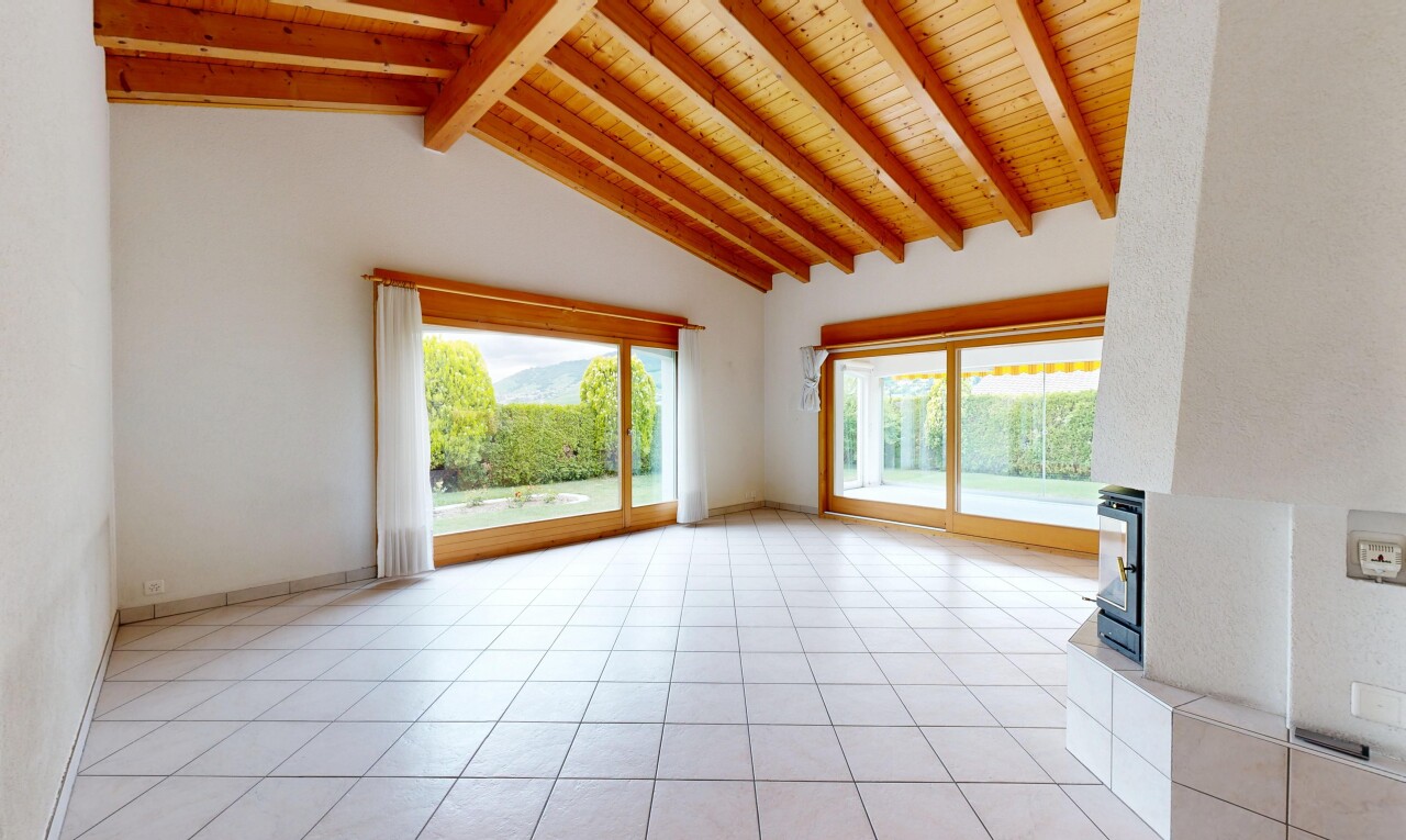 pièce vide avec inside property, light floor, beamed ceiling, plafond à poutres, et natural light