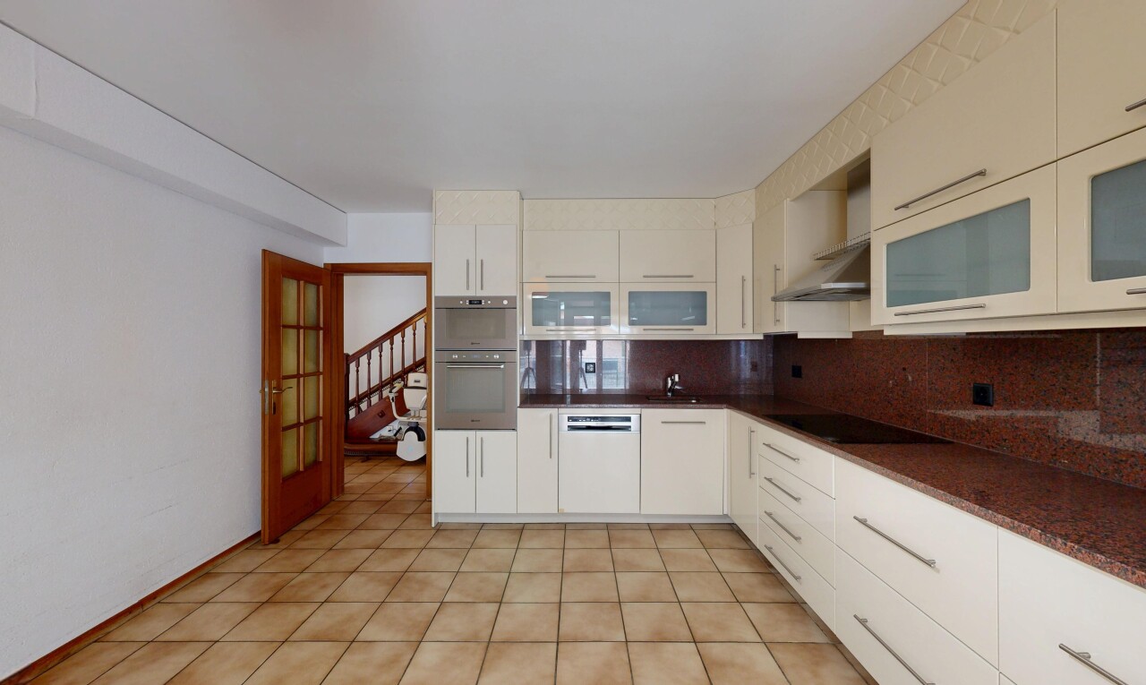 cuisine avec plans de travail, dark countertops, escaliers, dosseret, et backsplash