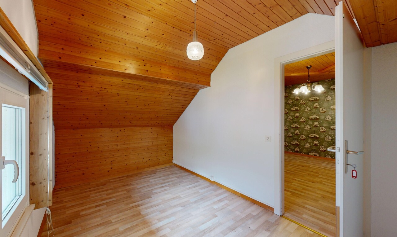 pièce vide avec wood finish floor, sol en finition bois, drywall, cloison sèche, et vaulted ceiling