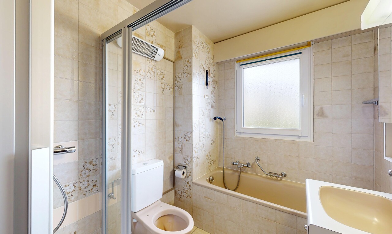 salle de bains avec salle de bain complète, douche, toilette, mur en carrelage, et tile wall