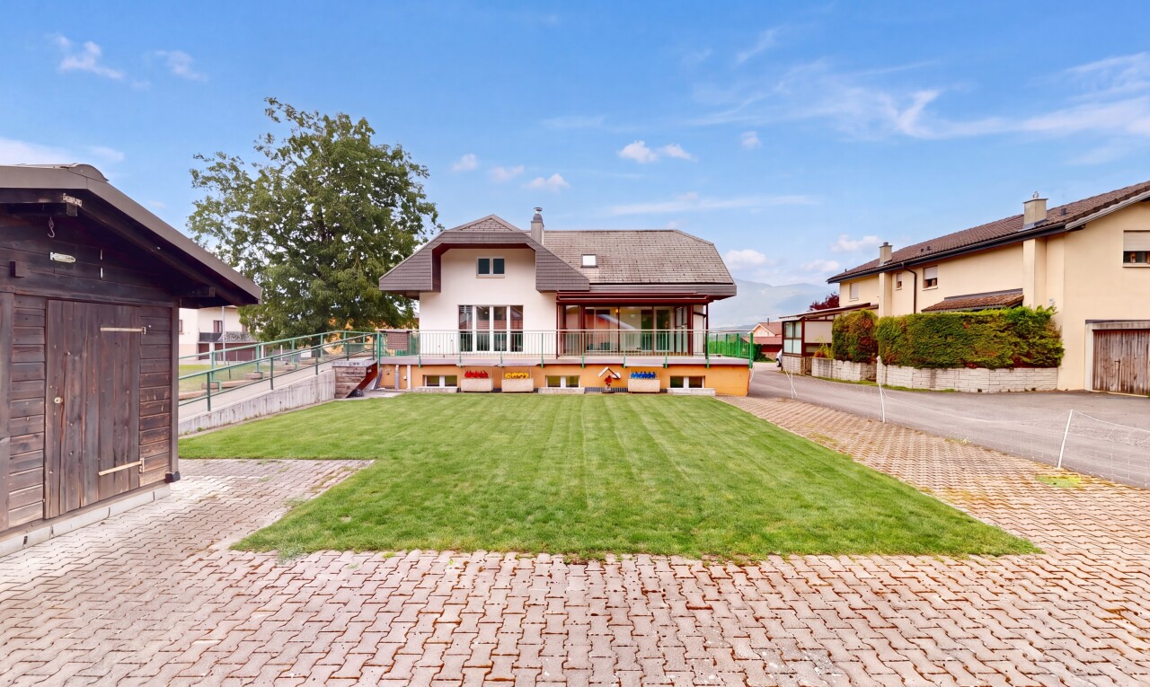 façade avec property visible, pelouse, terrasse, cheminée, et day time