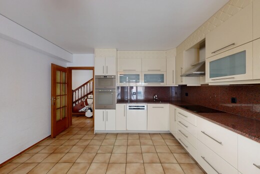 kitchen featuring dark countertops, tasteful backsplash, white dishwasher, glass fronted cabinets, and double oven