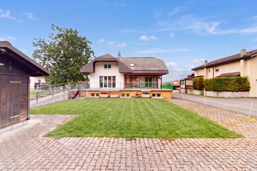 façade avec property visible, pelouse, terrasse, cheminée, et day time