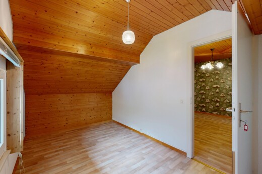 pièce vide avec wood finish floor, sol en finition bois, drywall, cloison sèche, et vaulted ceiling
