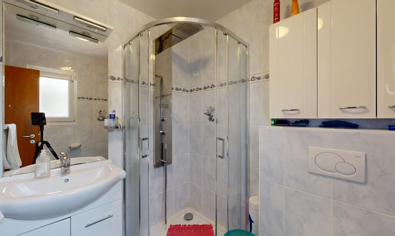 salle de bains avec tile wall, mur en carrelage, salle de bain complète, douche, et lavabo (ou coiffeuse selon le contexte)