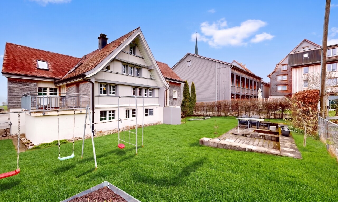 außenansicht mit spielplatz, schornstein, rasen, und day time