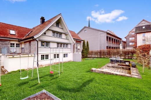 außenansicht mit spielplatz, schornstein, rasen, und day time