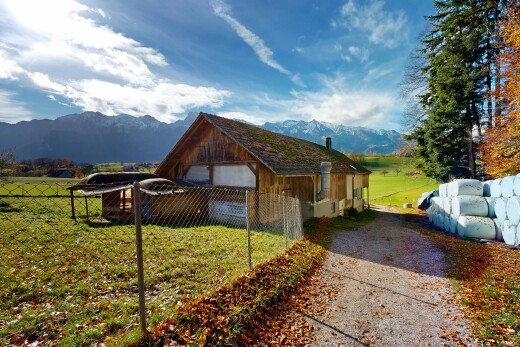 außenansicht mit zaun, rasen, mountain view, blick auf die berge, und property visible
