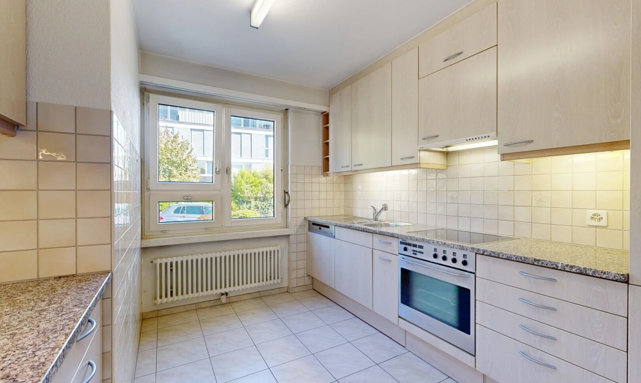 cuisine avec light countertops, stone countertops, plans de travail en pierre, radiateur, et four