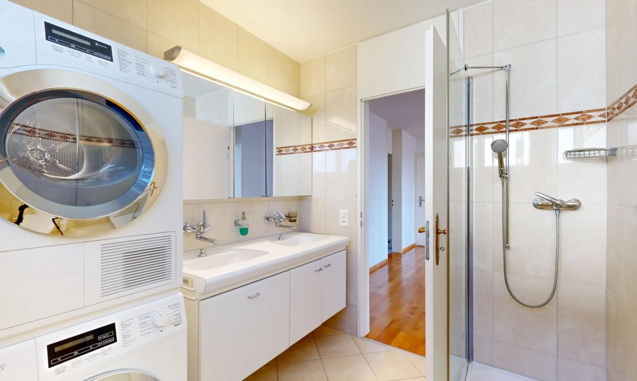 buanderie avec buanderie, light floor, tile floor, sol en carrelage, et lave-linge et sèche-linge superposés