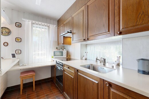 küche mit medium brown cabinets, mittelbraune schränke, light countertops, arbeitsplatten, und dark floor
