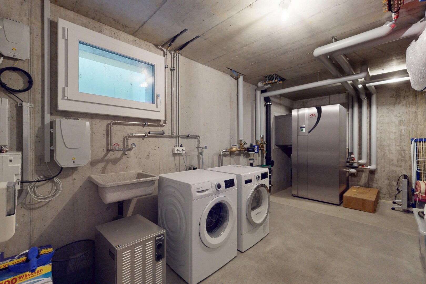 buanderie avec sous-sol, raccordement pour lave-linge, lumière naturelle, lave-linge et sèche-linge séparés, et buanderie