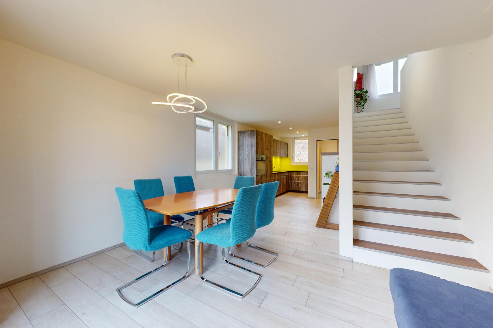 salle à manger avec lumière naturelle, lustre remarquable, cloison sèche, et escaliers