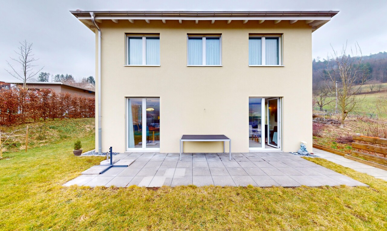 façade avec bardage en stuc, terrasse, et pelouse