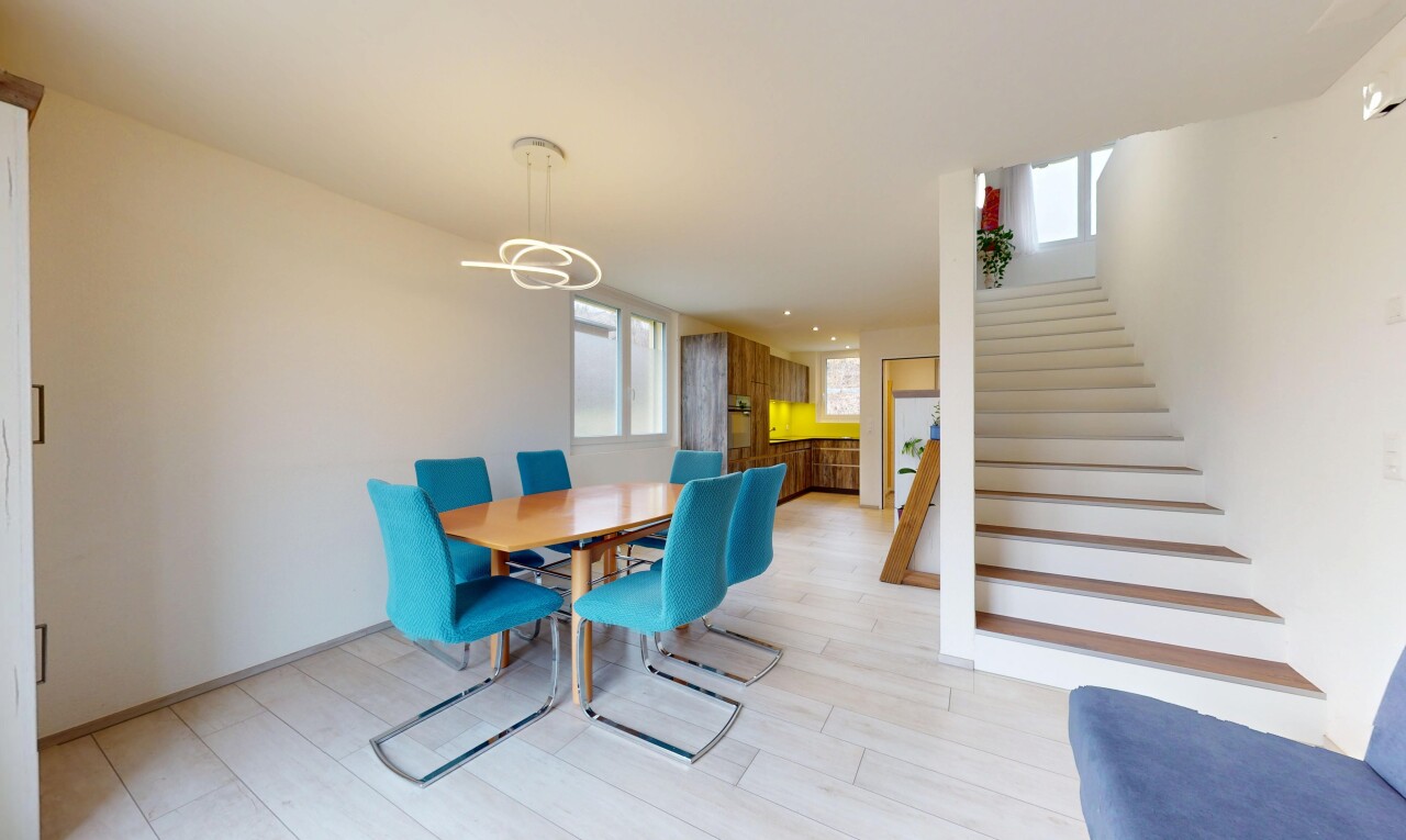 salle à manger avec lumière naturelle, lustre remarquable, cloison sèche, et escaliers