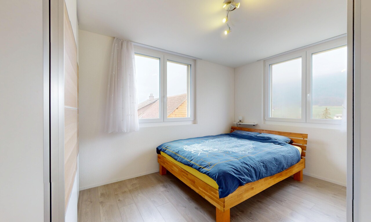 chambre avec sol en finition bois, lumière naturelle, éclairage sur rail, et cloison sèche